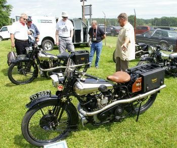 Owner Bryan Bossier, right, shows off some of the elegant, pricey Brough Superiors on display last weekend at the Duchess County Fairgrounds in New York. Among the spectators is Gary Randall of Harwinton, back left. Bud Wilkinson / Republican-American 
