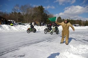 Race director Brent Sellew drops the green flag to start another heat during on the opening day of ice racing in Sturbridge, Mass. Bud Wilkinson / Republican-American  