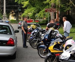 Kent's resident state trooper, Andrew Fisher, talks last Sunday with some motorcyclists about the growing problem the town is experiencing with noisy exhausts. Bud Wilkinson / Republican-American 