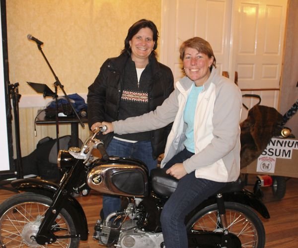 Denise Leclair, left, and Judy Finerghty and the 1965 Honda C110 that sold for $2,575 at auction at the Possum Queen pageant in Litchfield. Bud Wilkinson / Republican-American 