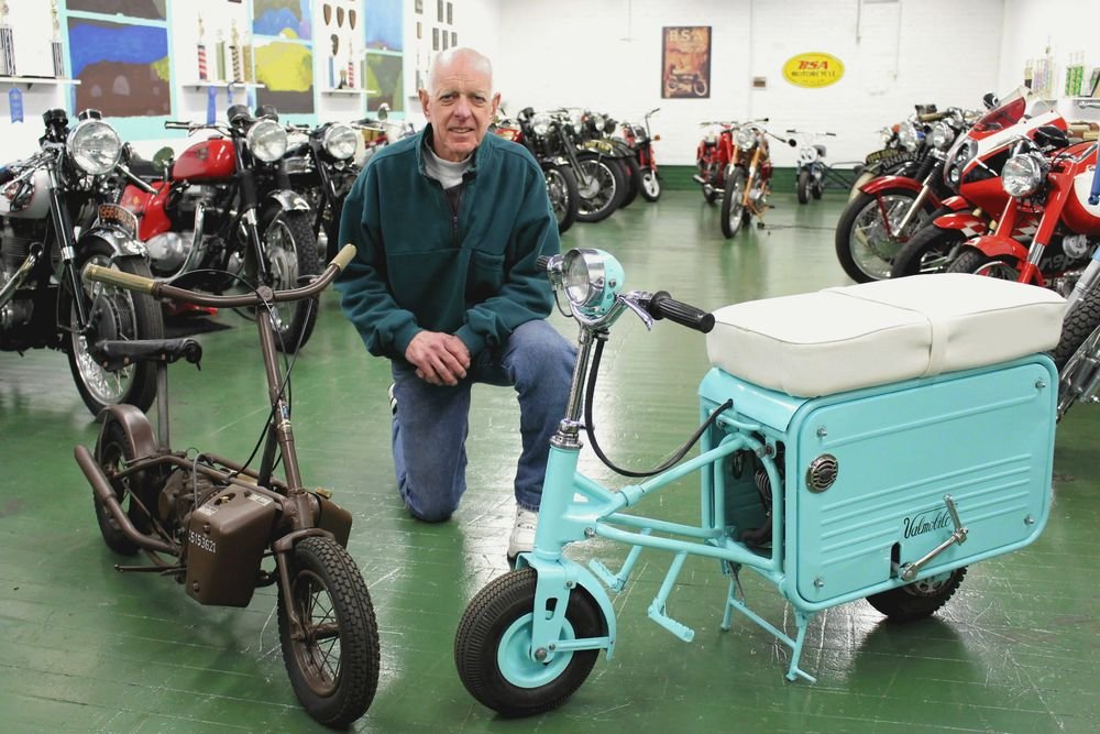 Motorcycle collector Mark Turkington of Bolton with his Welbike military model, left, and his Valmobile suitcase scooter, right. Bud Wilkinson Republican-American 